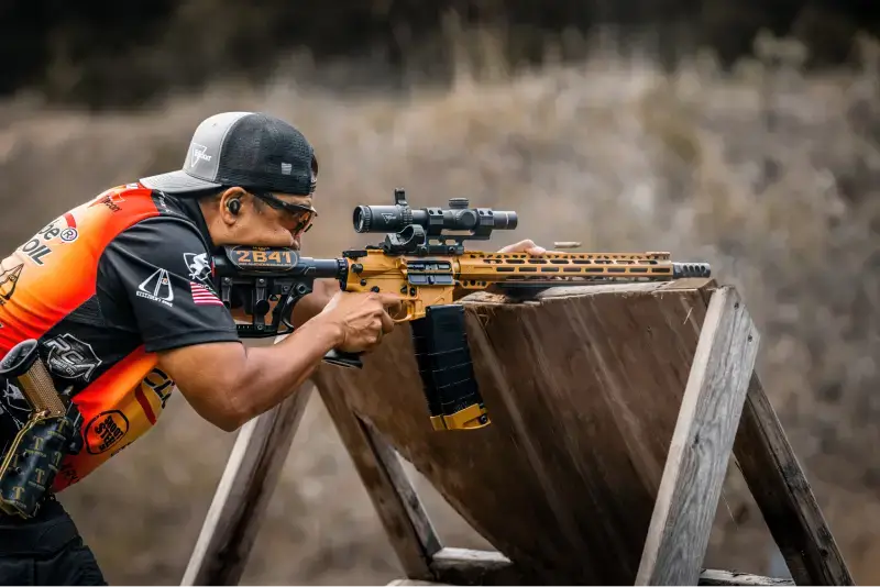 Man Shooting Gun On Wooden Stand